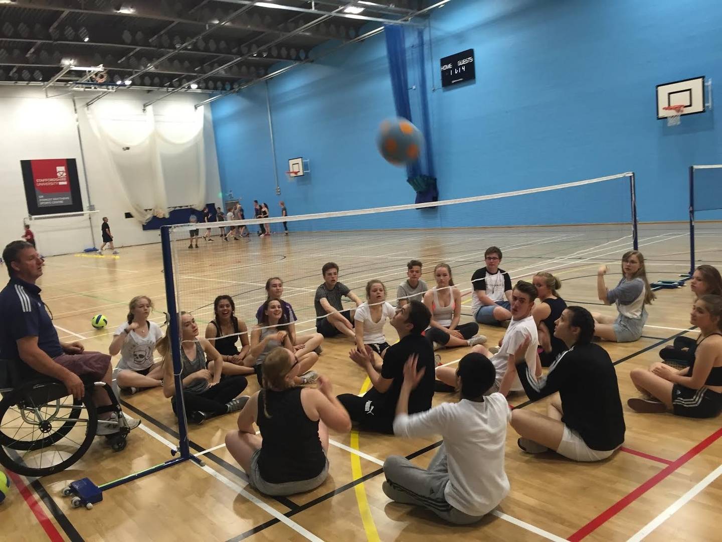 Young people playing sitting volleyball