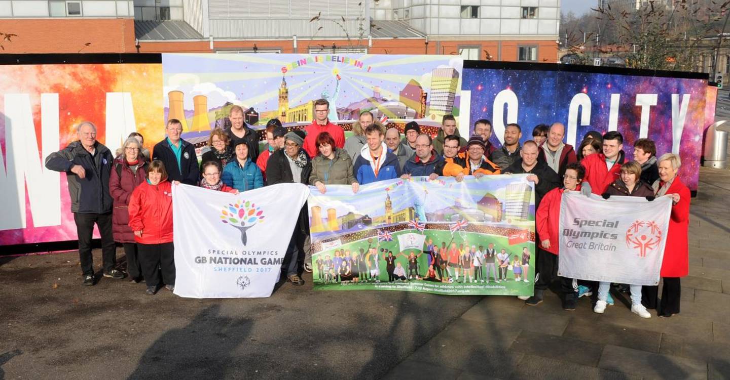 Athletes at launch of mural holding a banner for National Games 