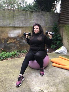 Jess exercising with weights and an exercise ball
