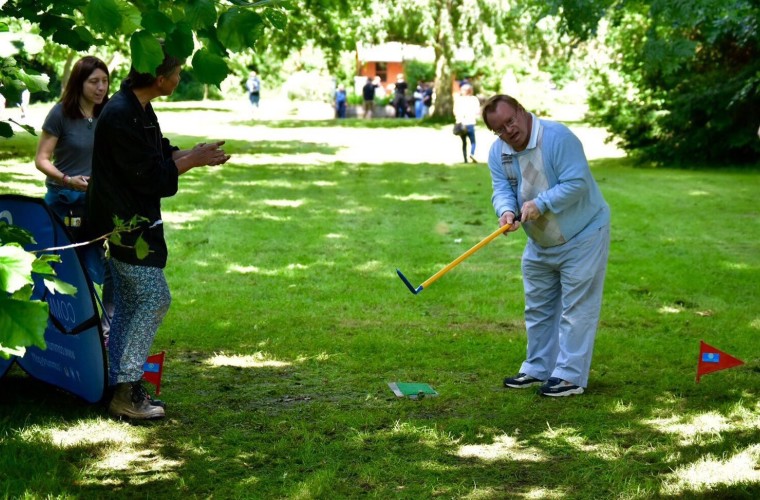 Man with a learning disability playing golf shot in tournament