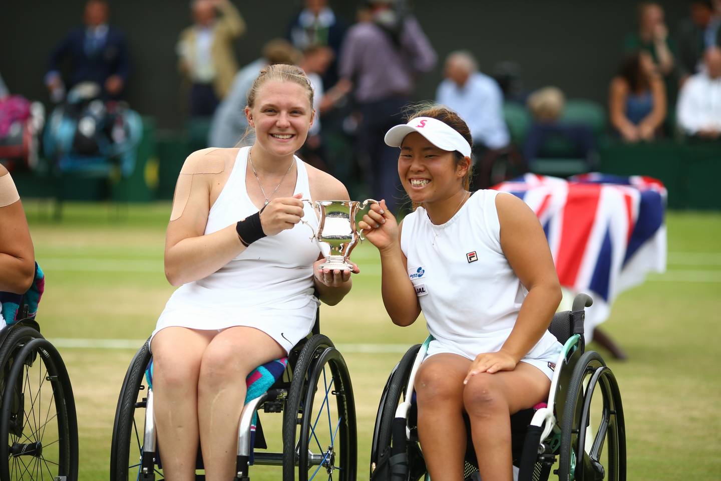 Ladies' Doubles partners Jordanne Whiley and Yui Kamiji holding winners trophy at Wimbledon.