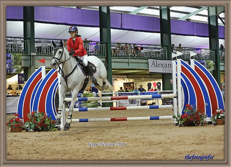Evie riding her horse at a showjumping event