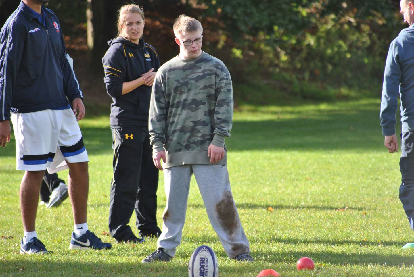 Boy with Down syndrome about to kick rugby ball