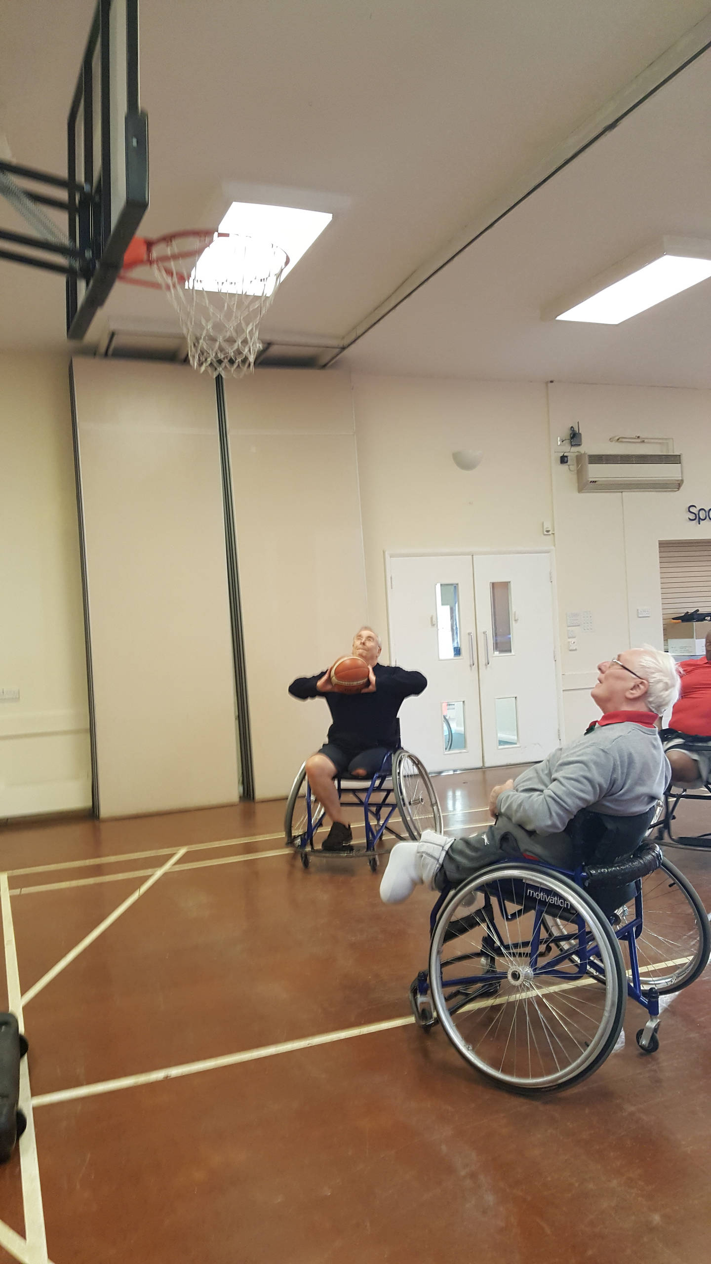 Two people playing wheelchair basketball. 