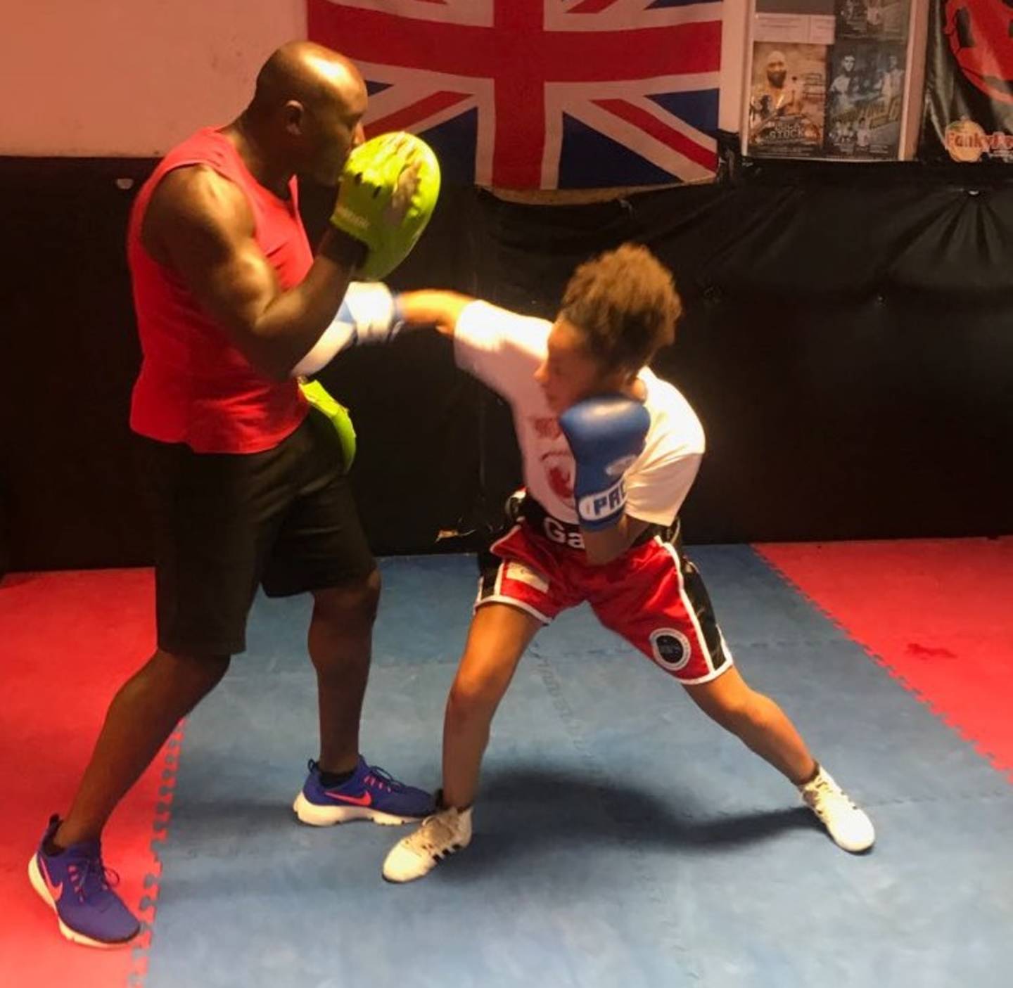Gabrielle boxing pads with her trainer