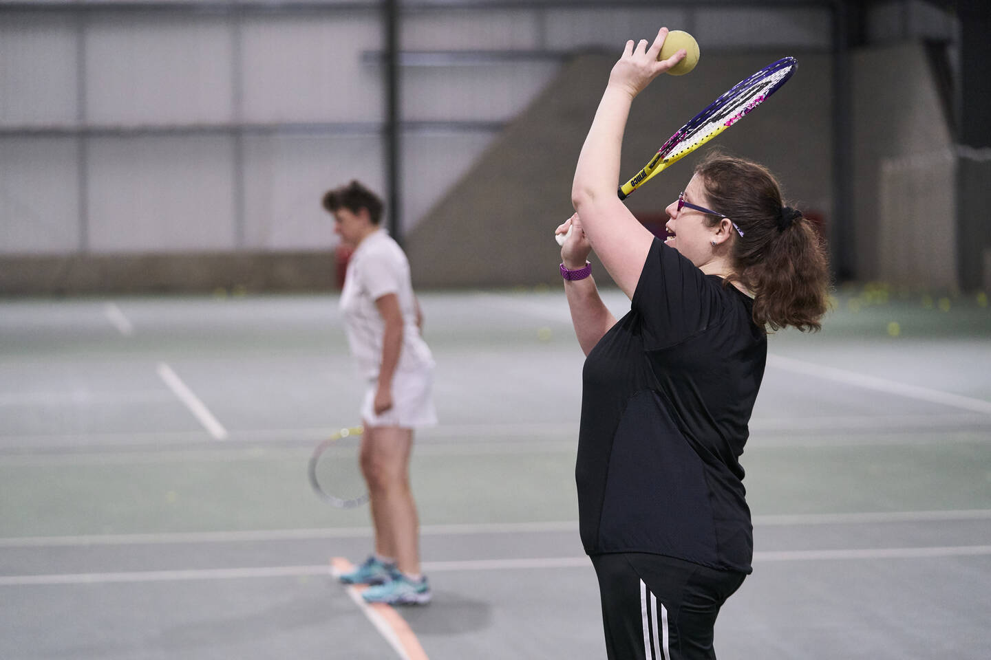 Two visually impaired women playing tennis together