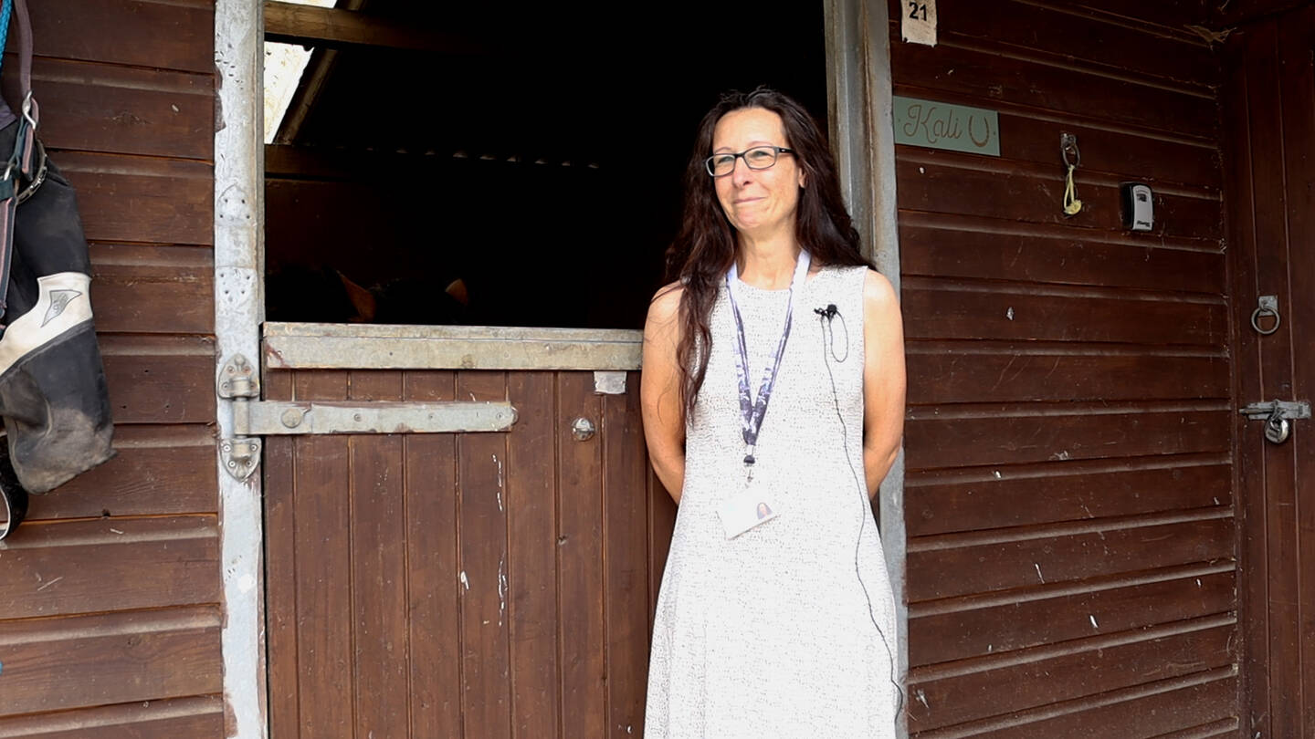 Linda, a Care Coordinator in Salisbury, stood next to a horses stable.