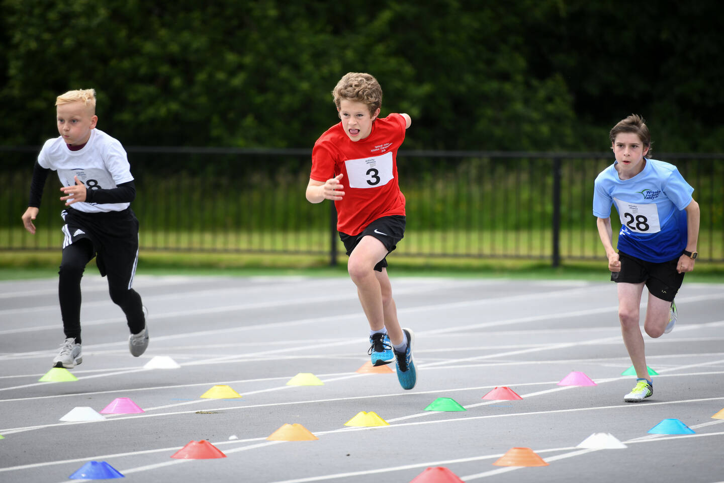 3 athletes taking part in 100m race at National Junior Athletics Championships 2022
