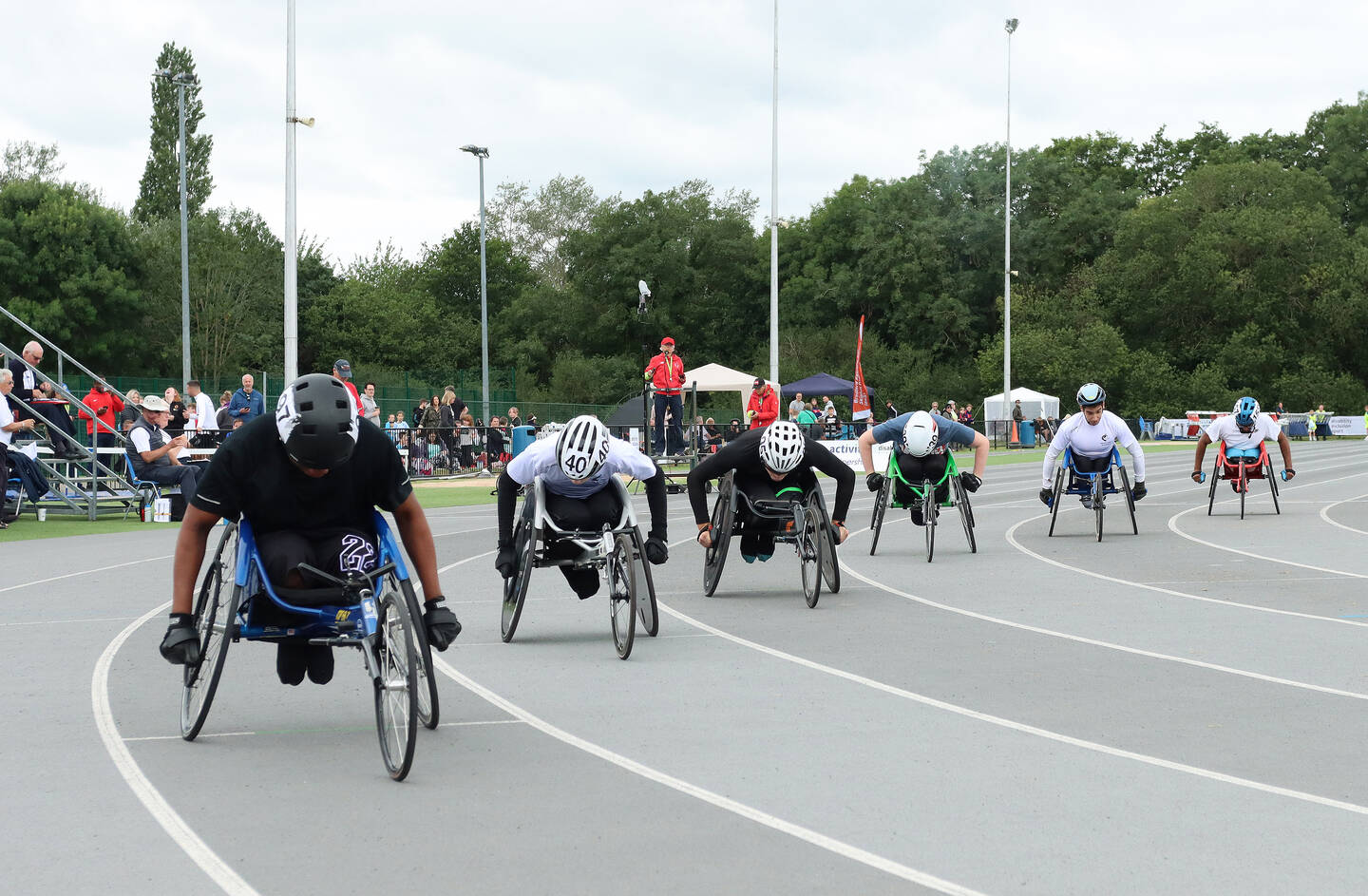 Five wheelchair racers line up on a track.