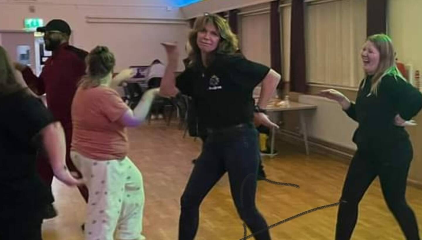Andrea dancing in a community hall at a SEN Disco. 